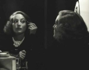Joan-Crawford-applies-max-Factor-makeup-1934b-696x552